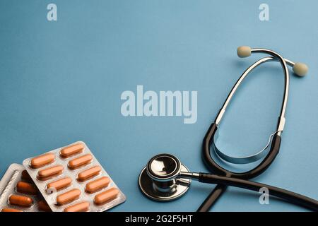 Stethoscope and pills on a blue background for medicine Stock Photo