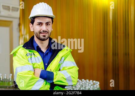 Portrait smart Latin worker in cargo port logistic warehouse standing confident with safety suit. Stock Photo