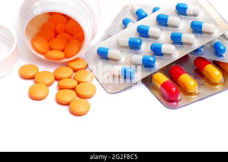 pills spilled from bottle and capsules in blister packs isolated on white background Stock Photo