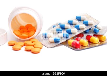 pills spilled from bottle and capsules in blister packs isolated on white background Stock Photo