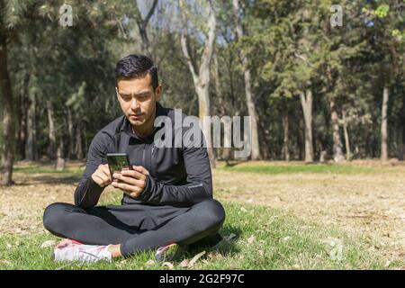 . Fit young latino man in sportswear standing in the forest Stock Photo