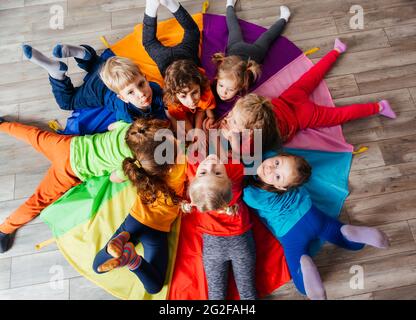 Cheerful children playing team building games on a floor Stock Photo