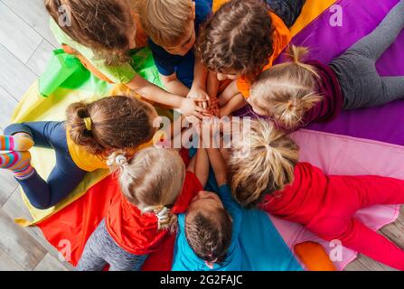 Cheerful children playing team building games on a floor Stock Photo