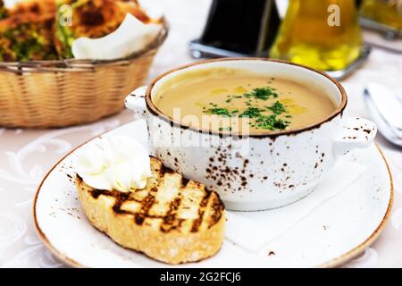 Mushroom cream soup. Soup in a bowl. Close up of bowl cream soup with mushroom and green parsley. Stock Photo