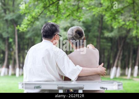 Happy old couple sitting on chairs in outdoor park high quality photo Stock Photo