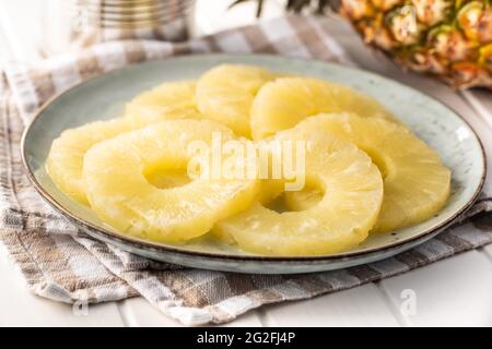 Canned sliced pineapple fruit on plate. Stock Photo