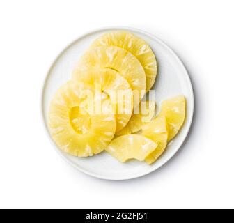 Canned sliced pineapple fruit on plate isolated on a white background. Stock Photo