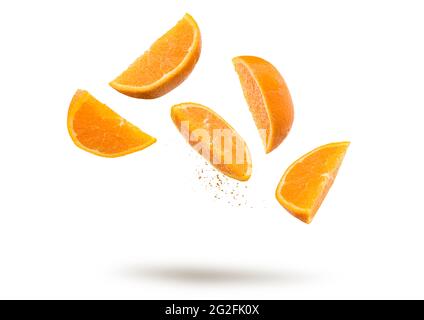 Orange fruit slices flying and dripping on white background Stock Photo