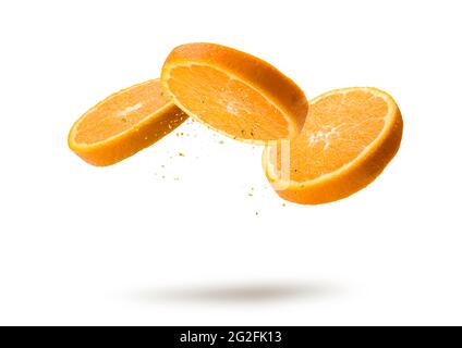 Orange fruit slices flying and dripping on white background Stock Photo