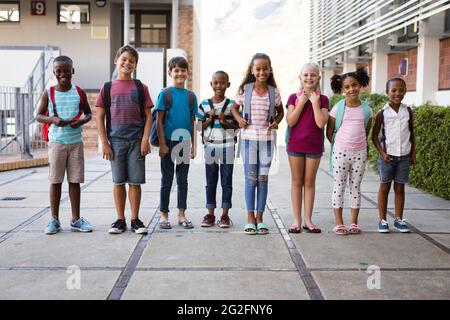 Portrait of group of diverse students smiling together while standing at school Stock Photo