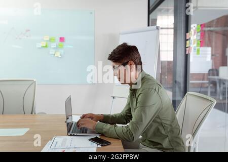 Asian businessman sitting in meeting room using laptop Stock Photo