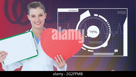 Composition of smiling female doctor holding heart and clipboard with medical data processing Stock Photo