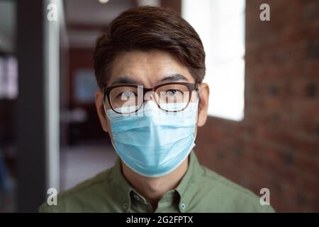 Portrait of asian businessman wearing face mask in office looking to camera Stock Photo