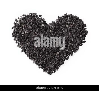Heart shape of black sand or charcoal isolated on white background. Symbol of love, care and romance for greating card. Dark goth style heart sign. Stock Photo