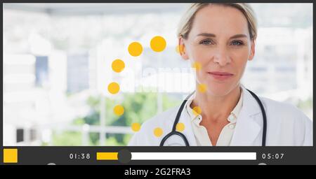 Composition of female doctor smiling on video playback interface screen Stock Photo