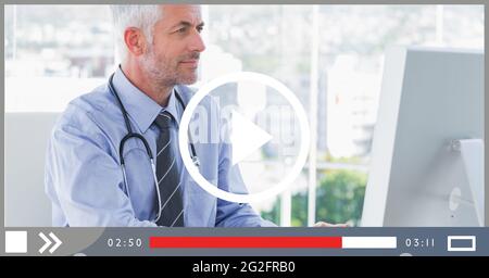 Composition of male doctor using computer on video playback interface ...