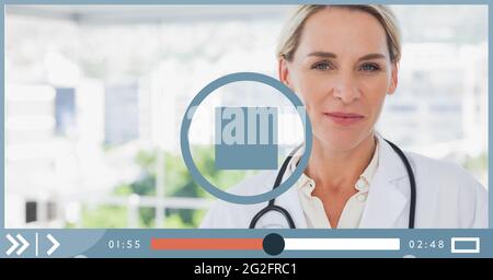 Composition of female doctor smiling on video playback interface screen Stock Photo