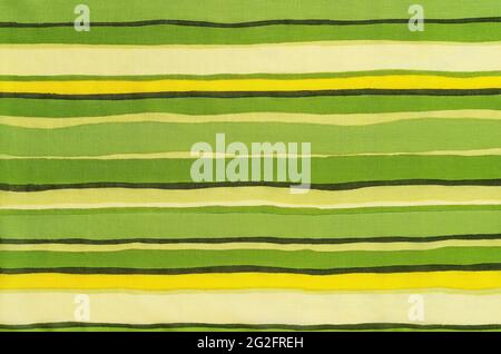 Colorful striped fabric texture. Thin cotton cloth with horizontal colored lines pattern. Textile with green yellow beige brown stripes as background. Stock Photo