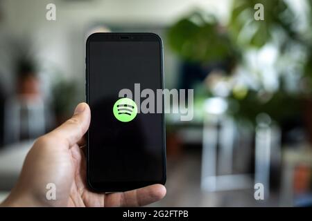 Spotify app opening, as seen on a phone screen Stock Photo