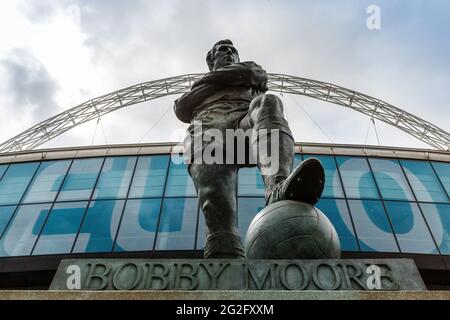 Wembley Stadium, Wembley Park, UK. 11th June, 2021. Bobby Moore Statue with 'EURO' displayed on Wembley Stadium LED screen behind. Wembley Park is ready to welcome England and Croatia fans on Sunday, the first UEFA European Football Championship to be played at Wembley Stadium Postponed by a year as the Coronavirus pandemic hit worldwide in 2020, the tournament starts today, with Wembley Stadium hosting it's first match, England v Croatia, on 13th June 2021. Credit: amanda rose/Alamy Live News Stock Photo