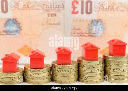 Rising stacks of coins with houses on top, to represent a rising property market. Stock Photo