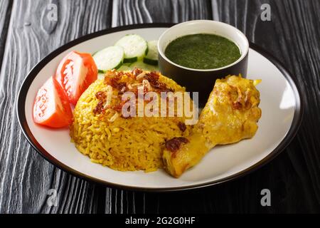 Asian Chicken Biryani Recipe Khao Mok Gai with Dipping Sauce closeup in the plate on the table. Horizontal Stock Photo