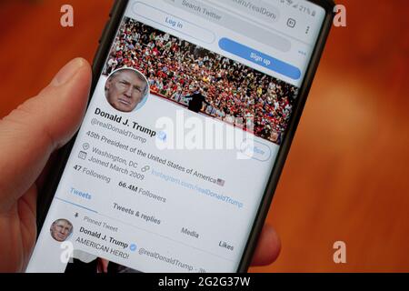 Trumps twitter page on a phone held by a hand Stock Photo