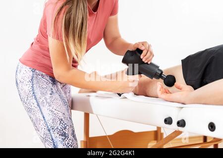 Closeup of physiotherapist using massage gun on female patient.  Chiropractor using massage gun on patient arm, Percussion or vibration  therapy on body 30964983 Stock Photo at Vecteezy