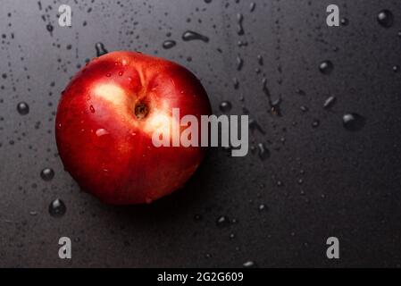 Nectarine fruit isolated on wet black background Stock Photo