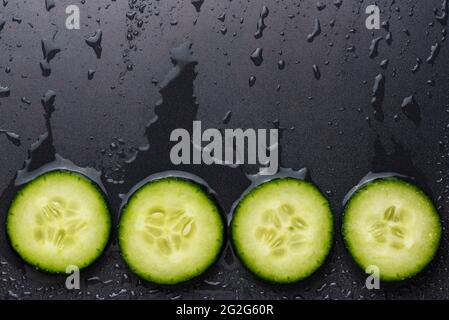 Isolated cucumber slices. Pieces of fresh cucumber isolated on black background Stock Photo