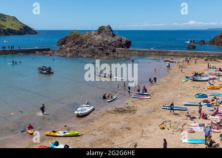 Holiday makers and boats on the beach at the holiday village of Hope Cove in the South Hams, Devon near Kingsbridge Stock Photo