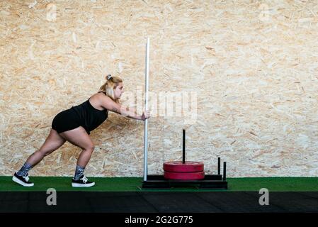 Strong Woman Doing Sled Training At Gym Stock Photo