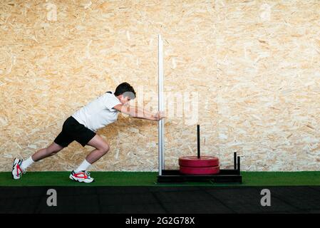 Young Strong Man Doing Sled Training At Gym Stock Photo
