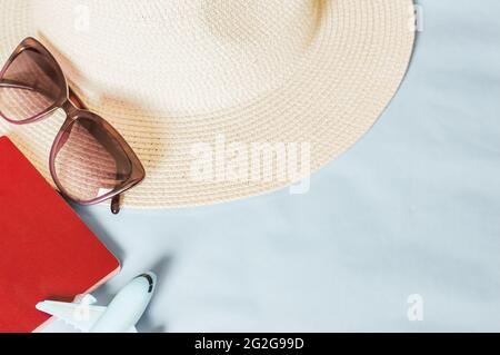 Vacation travel adventure trip concept. Minimal simple flat lay with plane, passport ,sunglasses, hat on color background. Stock Photo