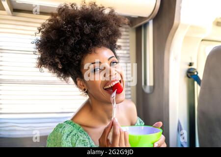 Pretty African woman eating a healthy strawberry Stock Photo