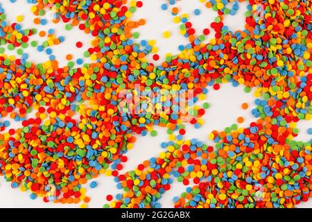 Vivid sugar sprinkle dots, decoration for cake on white background. Confectionery colorful decorative topping. Stock Photo