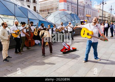 Performance of street musicians in Puerta del Sol. The Puerta del Sol, Gate of the Sun, is a public square in Madrid, one of the best known and busies Stock Photo