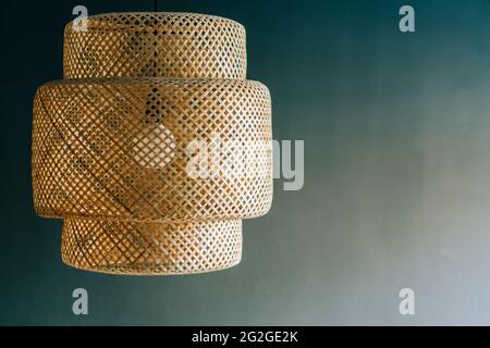 Wicker lamp hanging from the ceiling gray background Stock Photo