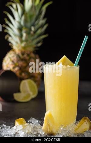 Cocktail with pineapple, coconut and lemon on stone background Stock Photo