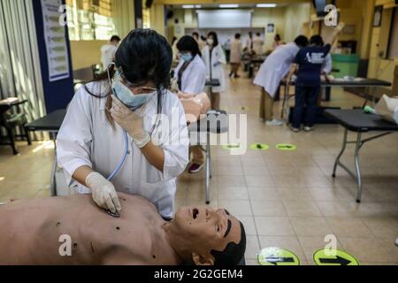 Manila, Philippines. June 10th 2021. Medical students perform a clinical skills exercise on an electronic dummy during a face-to-face class at the University of Santo Tomas. The university started its limited face-to-face classes after the government allowed the resumption hands-on training and laboratory classes in campuses while observing health protocols to prevent the spread of the coronavirus disease. Stock Photo