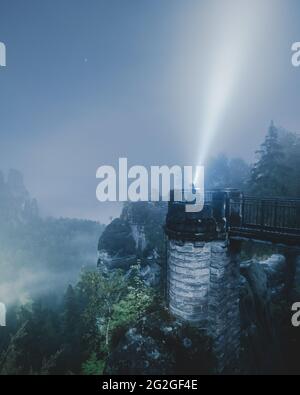 Nocturnal view from the Bastei bridge in the misty Elbe Sandstone Mountains. Stock Photo