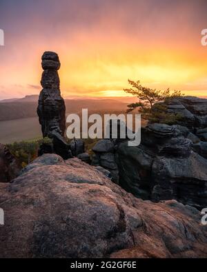 Colorful sunrise behind the Barbarine on the Pfaffenstein in the Elbe Sandstone Mountains. Stock Photo