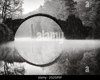 Black and white shot of the historic Rakotzbrücke in the Kromlau Rhododendron Park. Stock Photo