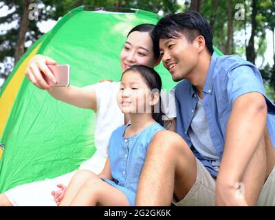A happy family of three takes a selfie in the park high quality photo Stock Photo