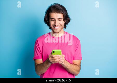 Portrait of attractive cheerful focused guy using device browsing web wi-fi blogging isolated over bright blue color background Stock Photo
