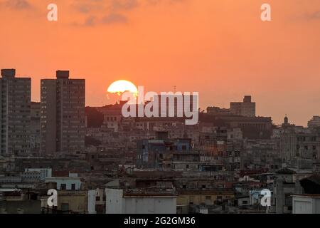 A beautiful low sun setting over the rooftops of old apartment buildings in Centro Habana, Cuba Stock Photo