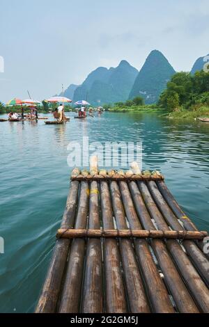 Tourists sailing in bamboo raft on Yulong River surrounded by karst mountains in Guilin, China Stock Photo