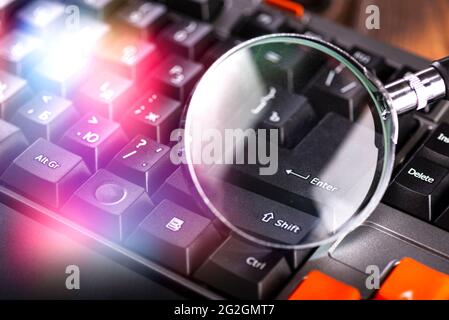 Closeup images of magnifying glass on laptop keyboard. Stock Photo