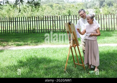 Happy old couple painting in the park high quality photo Stock Photo