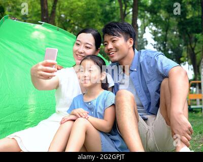 A happy family of three takes a selfie in the park high quality photo Stock Photo